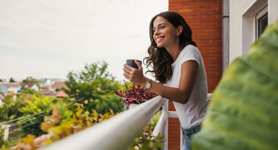 A woman holding a mug on a balcony