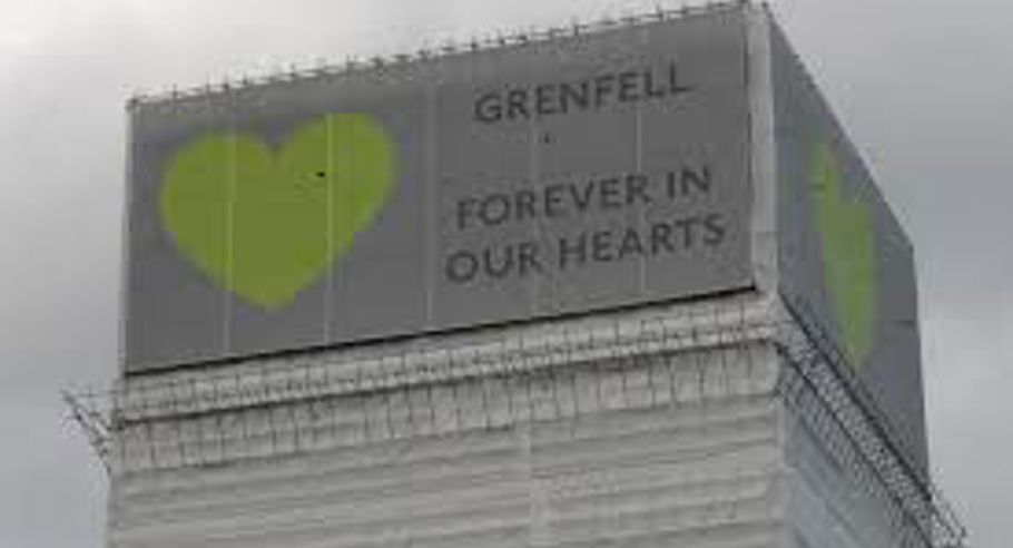 Grenfell tower with sign 'Grenfell, Forever in our hearts'
